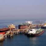 Oil tankers at a Persian Gulf terminal; shipping traffic through the nearby Strait of Hormuz has run at roughly 5% of pre-war levels since fighting began in February