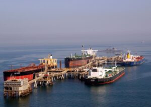 Oil tankers at a Persian Gulf terminal; shipping traffic through the nearby Strait of Hormuz has run at roughly 5% of pre-war levels since fighting began in February