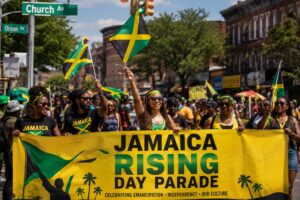 Marchers carry the Jamaica Rising Day Parade banner at Church Ave and Ocean Ave in Brooklyn