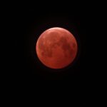A lunar eclipse turns the moon a copper-red color; a deep partial eclipse peaked before dawn on August 28, 2026
