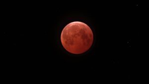 A lunar eclipse turns the moon a copper-red color; a deep partial eclipse peaked before dawn on August 28, 2026