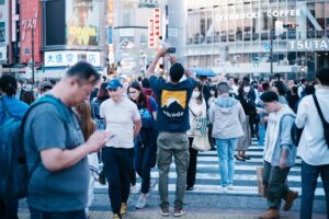 A packed pedestrian crossing in Tokyo, the kind of crowded public scene the 'Empty Universe' editing trend erases entirely