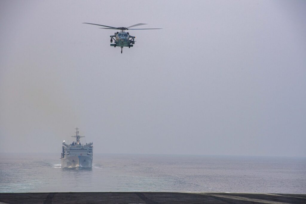A US Navy carrier strike group transits the Strait of Hormuz, where US forces struck Iranian rocket launchers on Larak Island before Iran retaliated against American bases in Jordan