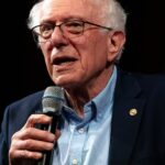 Senator Bernie Sanders speaking at a lectern about AI governance