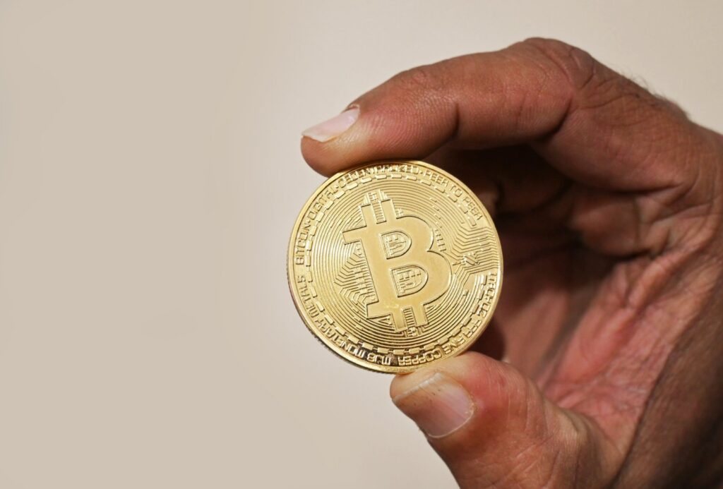A person holding a physical bitcoin token