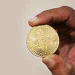 A person holding a physical bitcoin token