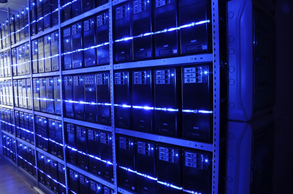 Interior view of a data center showing rows of illuminated server racks used for cloud and AI computing.