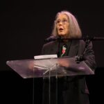 Anne Carson reading at a podium